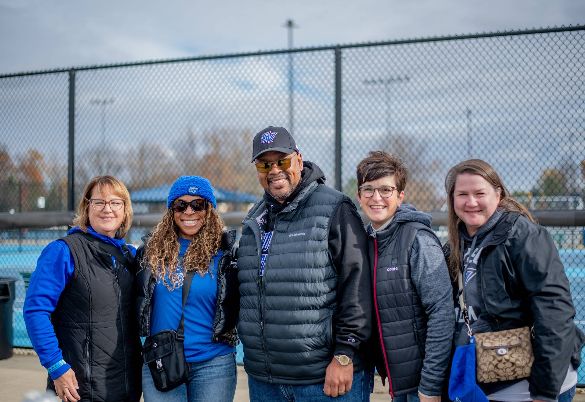 Five Lakers smile wearing GV gear at the tennis courts